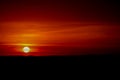 Blood red sunsetlight on the sky, sun at horizon Royalty Free Stock Photo