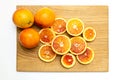 Blood Sicilian oranges on wooden cutting board. Sliced ripe juicy citrus fruits on white background. Top view