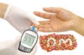 Blood sugar value is measured on a finger by female doctor in white medical gloves and decorative sprinkles sugar in alphabet