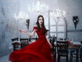 Bloodthirsty female vampire in red dress. Medieval interior Royalty Free Stock Photo