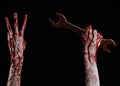 Bloody hand holding a big wrench, bloody wrench, big key, bloody theme, halloween theme, crazy mechanic, black background Royalty Free Stock Photo