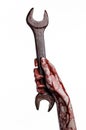 Bloody hand holding a big wrench, bloody wrench, big key, bloody theme, halloween theme, crazy mechanic, white background Royalty Free Stock Photo