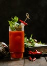 Bloody mary cocktail with red hot peppers and celery on wooden background with bar shaker Royalty Free Stock Photo