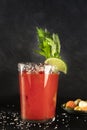 Bloody Mary cocktail with tomato juice, lime, and celery, wiuth pickles, side view on a black background Royalty Free Stock Photo