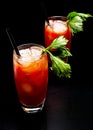 Bloody Mary cocktails with ice cubes and celery isolated on black Royalty Free Stock Photo