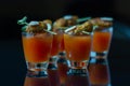 Bloody Mary cocktails in the shots drink served with Halloween bloody fingers, pork cocktail sausages decorated with flaked