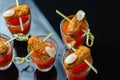 Bloody Mary cocktails in the shots drink served with Halloween bloody fingers, pork cocktail sausages decorated with flaked