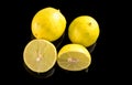 Bloody orange whole and halves, slices with reflection on white and black background in a spray of water