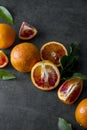 Bloody oranges slices with fresh leaves. Abstract citrus fruit background, horiyontal with copy space.