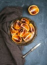 Bloody red sicilian oranges cut into quarters in vintage metal plate over concrete textured background Royalty Free Stock Photo