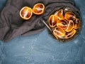 Bloody red sicilian oranges cut into quarters in vintage metal plate over concrete textured background Royalty Free Stock Photo