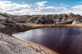 Lake with red bloody water at the bottom of clay quarry