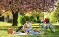 Blooming garden. Perfect spring date. Romantic picnic. Man and woman in love. Couple sit blanket. Happy together. Picnic