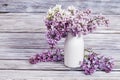 Blooming Lilac flowers in white vase on wooden background with copy. Bouquet of flowers as spring gift Royalty Free Stock Photo
