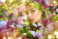 Blooming magnolia trees. Beauty young woman touching and smelling spring magnolia flowers Royalty Free Stock Photo