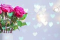 Blooming pink roses on electric hearts garland. Festive background for St valentines day. Greeting card with bokeh Royalty Free Stock Photo