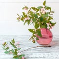 Blooming spring branches of flowers in glass pink vase on wooden vintage white background with copy space. Elegant home spring Royalty Free Stock Photo