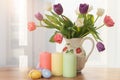 Blooming tulips, candles, Easter eggs, on the background of the window. Concept of congratulations on Easter, Happy Easter