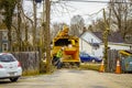 2021_03_24 Bloomington IN USA - City worker shoves cut tree branches into mulching  shredder chipper truck in alley in small town Royalty Free Stock Photo