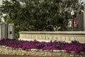 Bloomington USA - Gate into Indiana University with planter full of bright pink flowers and sign on lampost of Alumni