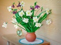 Blossoming narcissuses in a vase on a table. Royalty Free Stock Photo