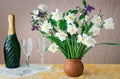 Blossoming narcissuses in a vase on a table. Royalty Free Stock Photo