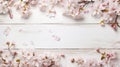 blossoming spring flowers and scattered petals on white rustic wooden texture table top view with copy space