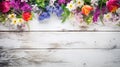 blossoming spring flowers on white rustic wooden table top view with copy space