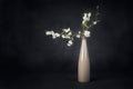 Blossoming twig with white flowers in a vase