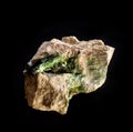 Blotting of green actinolite mineral crystals in rock from Ural, Russia. A backlight photo of a stone isolated on black. Geology