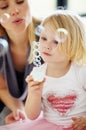 Blow, bubbles and games with mom and child together in home playing with toys for fun. Playful, mother and girl with Royalty Free Stock Photo