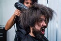 blow dry hair in barbershop of brutal mature shouting client man, hairdresser