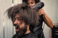 blow dry hair in barbershop of brutal mature shouting client man, hairdresser