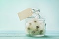 Blowball or dandelion in wishing jar with paper tag, vintage turquoise background, make a wish concept, unusual gift or present Royalty Free Stock Photo