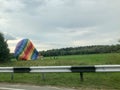 Blowed down deflate a large, colorful, colorful, round, rainbow colored, striped, flying balloon. The background