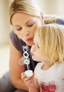 Blowing, bubbles and games with mom and child together in home playing with toys for fun. Playful, mother and daughter Royalty Free Stock Photo