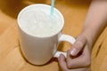 Blowing bubbles into milk through a blue straw