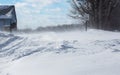 Blowing, drifting snow across a country road