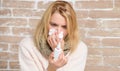 Blowing her nose. Pretty girl with runny nose holding nasal drops. Cute woman nursing nasal cold or allergy. Suffering Royalty Free Stock Photo