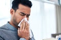 Blowing nose, sick and man with tissue for allergies, hayfever and sinus problem at home. Healthcare, flu symptoms and