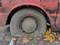 Blown tire of an old rusty car on a dirty road