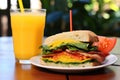 blt sandwich next to a glass of orange juice