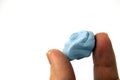 Blu Tack hold in hand. Close up photo of reusable and pressure sensitive adhesive paste commonly used to attach lightweight