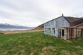 Blue abandoned farmhouse in icelandic fjord. Near Djupivogur inext to the ring road during road trip.