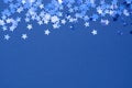 Blue abstract Christmas background or texture with stars confetti on blue background. Space for text Royalty Free Stock Photo