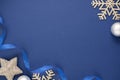 Blue abstract Christmas minimalistic styled background with silver snowflakes, baubles and blue ribbon. Blue mock up with space Royalty Free Stock Photo