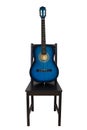 Blue acoustic guitar on a black wooden chair isolated over white background. Trendy musical instrument for playing good music. Royalty Free Stock Photo