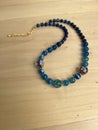 Blue agate and Venetian glass necklace on wooden table Royalty Free Stock Photo