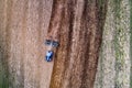 A blue agricultural tractor preparing a crop field in the spring in rural Estonia.