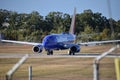 Blue aircraft with yellow and red empennage lining up on the runway at T.F. Green Airport Royalty Free Stock Photo